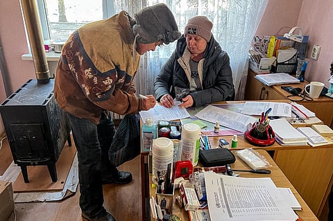Oleksiy Stepanov recives from doctor Elena Molchanova a death certificate for his 83-year-old neighbour at a health centre in Bakhmut, Donetsk region, on January 11, 2023. (Photo | AFP)