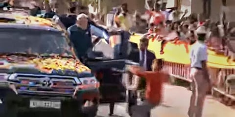 A youngster tries to hand a garland to Prime Minister Narendra Modi while allegedly breaching his security cover during his roadshow. (Photo | PTI)