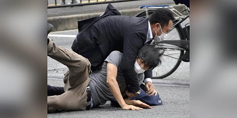 Tetsuya Yamagami, bottom, is detained near the site of gunshots in Nara Prefecture, western Japan, on July 8, 2022. (Photo | AP)