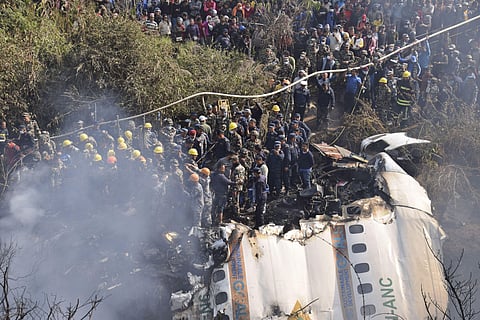 Nepalese rescue workers and civilians gather around the wreckage of a passenger plane that crashed in Pokhara, Nepal (Photo | AP)
