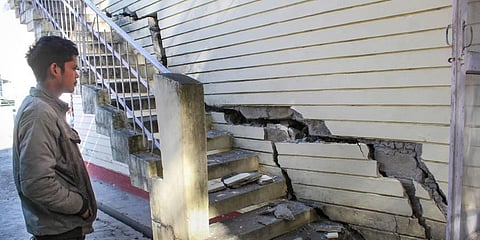 A man looks at cracks that appeared in a PWD Guest House, in a land subsidence-affected area in Joshimath, Jan. 16, 2023. (Photo | PTI) 