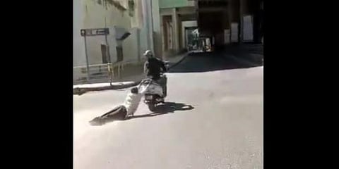 A screengrab from a  video which shows the man being dragged by the scooterist. (Screengrab)