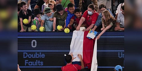 Daniil Medvedev of Russia autographs a Russian flag  at the Australian Open Monday, Jan. 16, 2023.(Photo | AP)