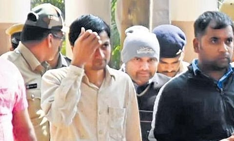 Police escort Santro Ravi (in cap) who was produced in a court in Mysuru | Express