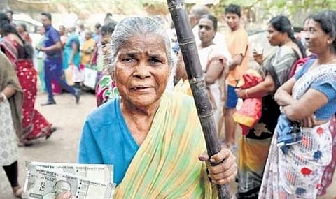 A woman showing the cash given to her at Lloyds Colony on Monday | R Satish Babu