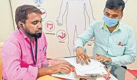 A man filling the form expressing his consent to donate his organs at the Organ Donation stall set up by the health department at the India Tourism and Industrial Trade Fair | R Satish Babu
