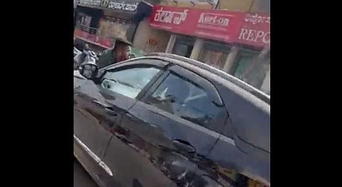 A screengrab from the video of businessman being dragged on an SUV bonnet