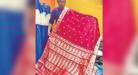 A weaver showcases a swarnachari sari