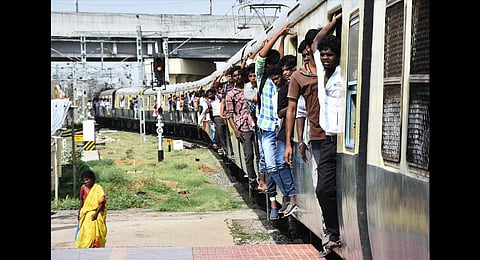 Commuters travelling on footboard in a suburban train in Chennai. (Photo | Ashwin Prasath, EPS)