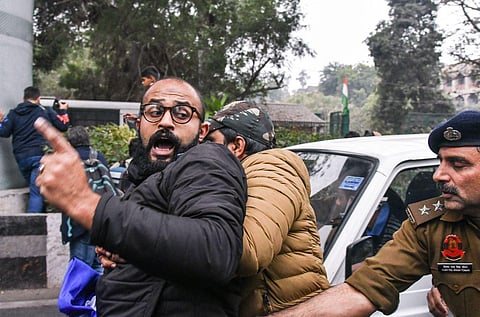Police detain an SFI activist during a protest against the detention of four activists over the proposed screening of a BBC documentary, at Jamia Millia Islamia. (Photo | PTI)