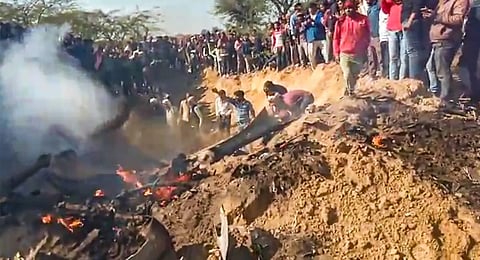 People gather near the wreckage of a crashed aircraft, in Bharatpur distric. (Photo | PTI)