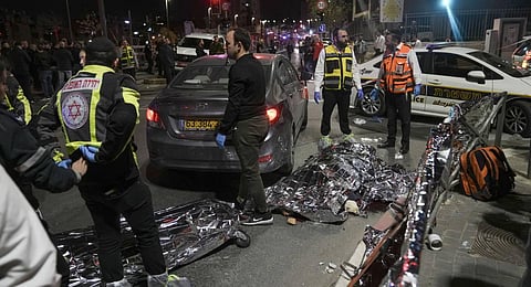 Victims of a shooting attack are covered on the ground near a synagogue in Jerusalem. (Photo | AP)