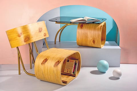 A curved chair with a rounded shelf at the bottom for stacking books