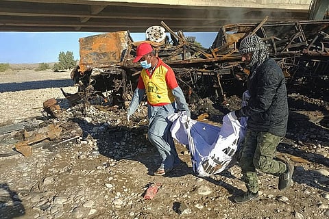 Rescue workers collect remains from the burnt wreckage of a bus accident in Bela, an area of Lasbela district of Balochistan province, Jan. 29, 2023. (Photo | AP)