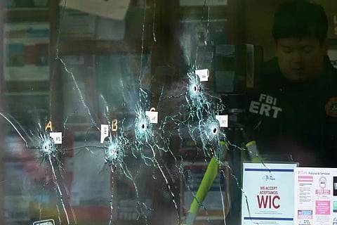 Bullet holes are seen in a window as an investigator works at the scene of a fatal shooting at a supermarket in Buffalo, N.Y., Monday, May 16, 2022. (Photo | AP)