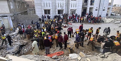 Security officials and rescue workers search bodies at the site of suicide bombing, in Peshawar, Pakistan. (Photo | AP)