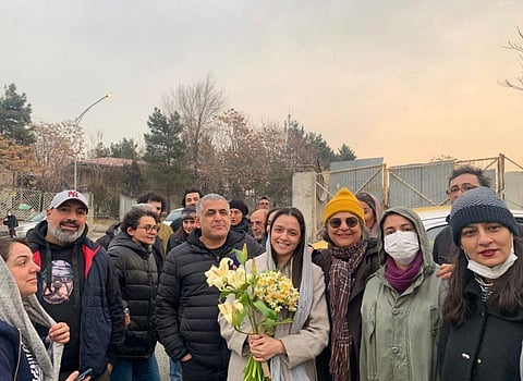Iranian actress Taraneh Alidoosti, center, holds bunches of flowers as she poses for a photo among her friends after being released from Evin prison in Tehran, Iran. (Photo | AP)