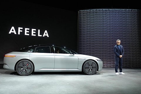 Yasuhide Mizuno, representative director, chairman and CEO of Sony Honda Mobility Inc. stands beside a newly unveiled electric vehicle prototype car 'Afeela' | AP