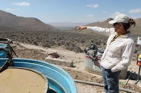 Melissa Boerst, a Lithium Nevada Corporation geologist, points to an area of future exploration from a drill site | AP