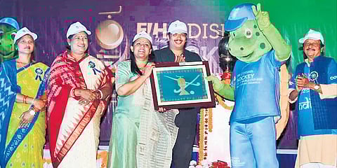 Collector Monisha Banerjee presenting a memento to hockey mascot Olly | Express