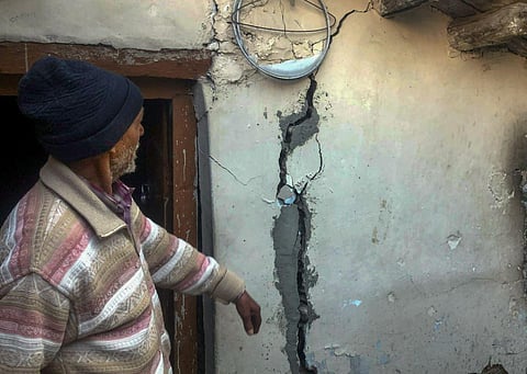 A man shows cracks appeared at his house at Joshimath in Chamoli district, Uttarakhand. (Photo | PTI)