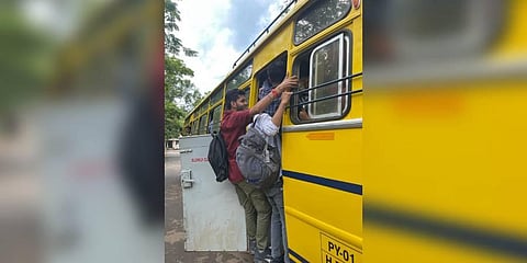 Pondicherry University students stand on the footpath of the already overcrowded bus. (Photo | Special Arrangement)