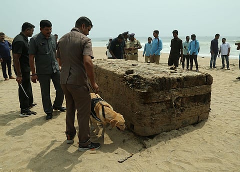 Dog squad and clue teams inspecting the wooden, mysterious box that washed ashore in Visakhapatnam, late on Friday night. (Photo | G Satyanarayana)