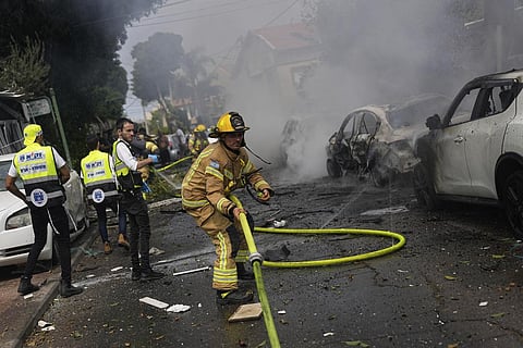 Israeli firefighters extinguish fire at a site struck by a rocket fired from the Gaza Strip, in Ashkelon, southern Israel, Monday, Oct. 9, 2023. (Photo | AP)