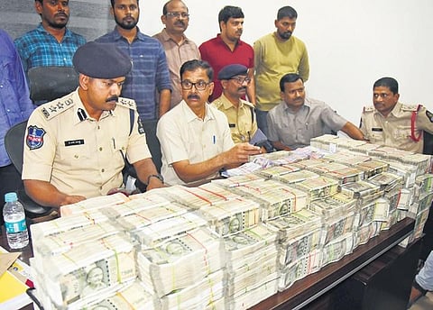 Task Force sleuths and Banjara Hills police personnel with the `3.35 crore seized from a car at Banjara Hills on Tuesday.