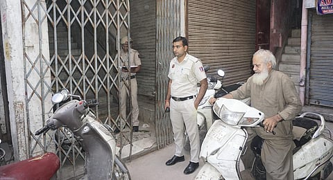 Police personnel stand guard as the National Investigation Agency (NIA) teams raid on the premises of the banned outfit Popular Front of India (PFI), in New Delhi (Photo | PTI)