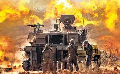 An Israeli army self-propelled howitzer fires rounds near the border with Gaza on Wednesday. The toll in Israel from the Hamas massacre has surged past 1,200 following the worst attack in the country’