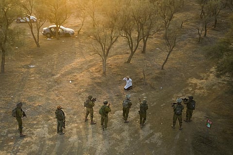 Israeli soldiers surround a Palestinian who ran at them with a knife at the site of a music festival near the border with the Gaza Strip on Oct. 12, 2023. (AP)