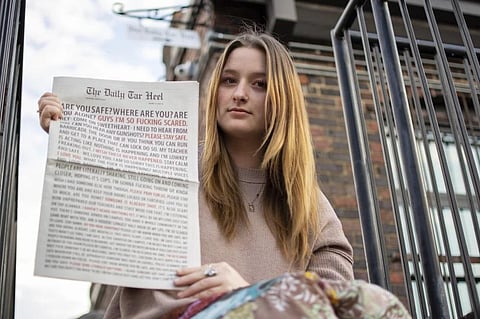 Emmy Martin, Editor in Chief of The Daily Tar Heel, the student newspaper of the University of North Carolina at Chapel Hill, with the Aug. 30 paper outside of the newsroom, Oct. 9, 2023. (Photo | AP)