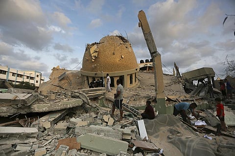People stand outside a mosque destroyed in an Israeli air strike in Khan Younis, Gaza Strip, Oct 8, 2023. (Photo | AP)