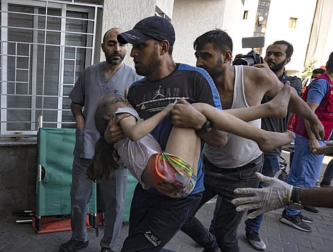 A child wounded in Israeli military strikes is brought to Shifa hospital in Gaza City. (Photo | AP)