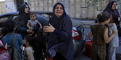 Palestinians rush to the street following Israeli airstrikes on Gaza City, central Gaza Strip, Sunday, Oct. 15, 2023 (Photo | AP)