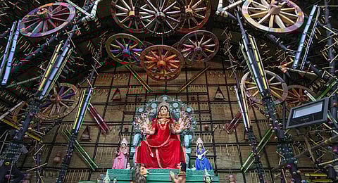 A Durga Puja pandal made with bullock cart wheel, ahead of Durga Puja festival in Kolkata, Sunday, Oct. 15, 2023. (PTI)