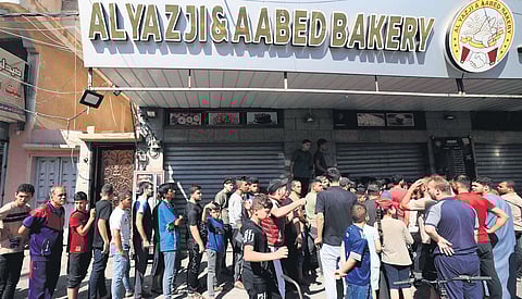 Displaced Palestinians queue for bread in Khan Yunis, southern Gaza on Sunday | afp