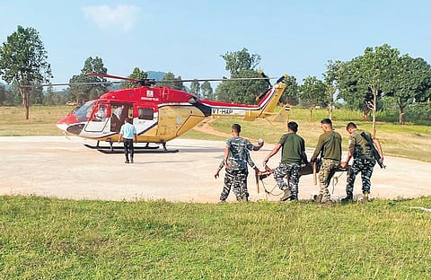An army helicopter awaits as the security personnel carry the Maoist | express