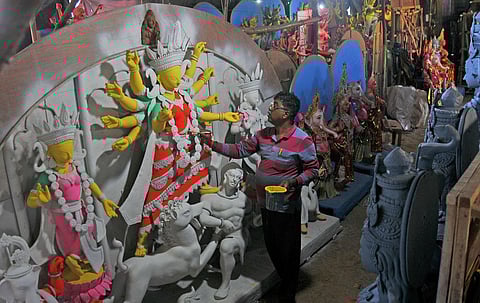 An artist gives the finishing touches to an idol of Goddess Durga ahead of the festivities. (Photo | Vinod Kumar T)