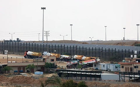 Trucks leave Gaza's Rafah border crossing with Egypt during an Israeli airstrike on 10 October, 2023. (AP)