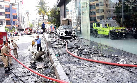 Due to the fire on the top floor, melted plastic and glass fell on the scooters parked next to the building. (Photo | Express)
