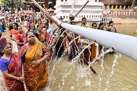 Devotees bathing in pipeline water in Thula Kattam during the first day of Kaveri Thula Utsavam on Wednesday | Express