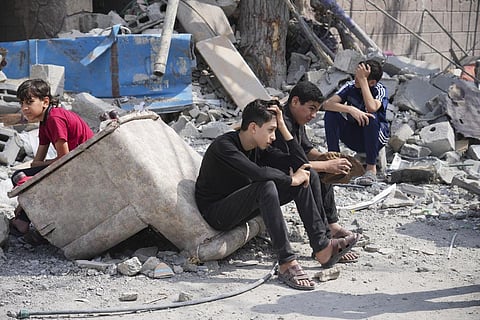 Palestinian boys sit on the rubble of a building destroyed in an Israeli airstrike in Nuseirat camp in the central Gaza Strip on Monday, Oct. 16, 2023. (AP)