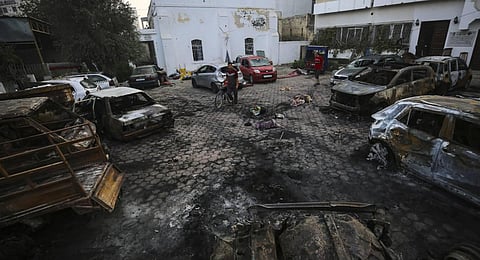 Palestinians check the area of the explosion at al-Ahli Hospital in Gaza City. (Photo | AP)