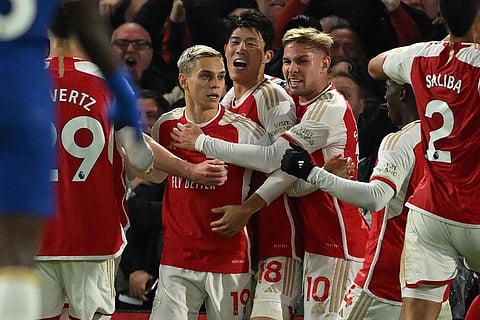 Arsenal's Belgian midfielder Leandro Trossard (centre left) celebrates with teammates after scoring their second goal during the EPL football match between Chelsea and Arsenal. (Photo | AFP)