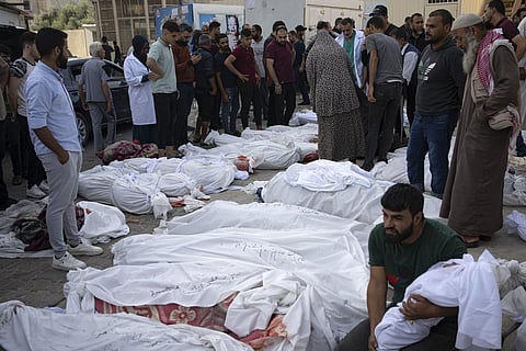 Friends and relatives stand by the bodies of Palestinians killed in the Israeli bombardment of the Gaza Strip at Al-Aqsa Hospital. (Photo | AP)