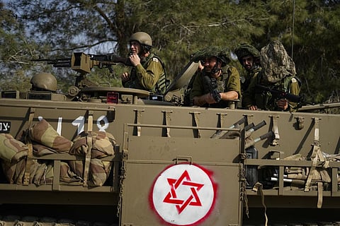 Israeli soldiers drive an armoured personnel carrier (APC) near the border with the Gaza Strip, in southern Israel, Sunday, Oct. 22, 2023. (Photo | AP)