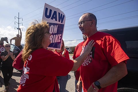 Patricia Eckel, left, speaks with Shawn Fain, president of the United Auto Workers, as he visits the picket line at Stellantis' Toledo Assembly Plant, Ohio, on Sept 30, 2023. (Photo | AP)