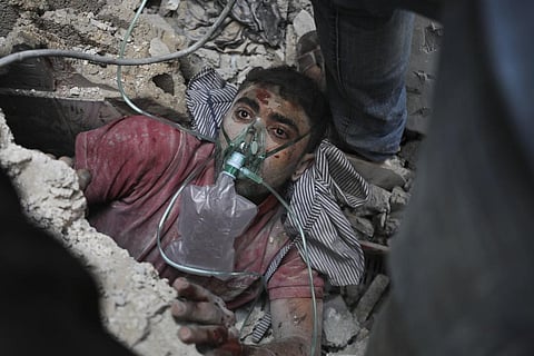Palestinians rescue a survivor of Israeli bombardment of the Gaza Strip in Nusseirat refugee camp. (Photo | AP)
